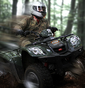Image shows a young thrill-seeker quad-biking through the woods at Bassetts Pole